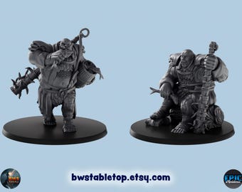 May include: Two gray painted miniature figures of orcs, one standing and holding a weapon, the other sitting and holding a staff. The figures are on black circular bases.