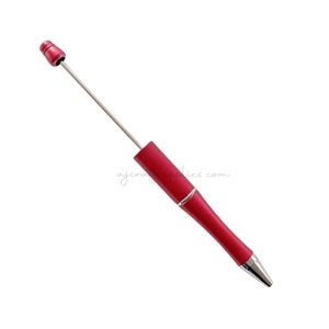 Könnte beinhalten: Ein roter, einziehbarer Kugelschreiber mit silberner Spitze und einem silbernen Band in der Nähe der Oberseite. Der Stift ist ausgefahren und die Kappe ist abgenommen.