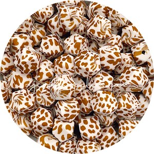 以下が含まれることがあります： 白地に茶色のレオパード柄がプリントされた白いシリコン製の歯固めビーズのクローズアップ。