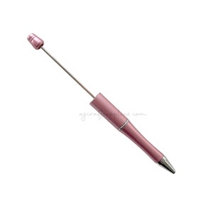 Könnte beinhalten: Ein roségoldfarbener Kugelschreiber mit silberner Spitze und silberner Kappe.