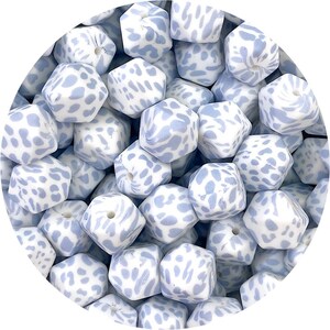 以下が含まれることがあります： 白と薄い青のパターンが施された薄い青のシリコン製ベビー用歯固めがいくつか集まっている様子のクローズアップ。歯固めは六角形です。