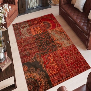 May include: A red, orange and brown patterned rug with a patchwork design. The rug has a distressed look and is made of a soft, plush material.