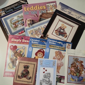 May include: A collection of ten assorted cross-stitch kits featuring teddy bear illustrations. The packaging includes titles such as Teddy Teatime, Teddies on the Line, Boyds Bears and Friends, Simply Sweet, Cherished Teddies Occupation Series, and Good Clean Fun, showcasing various bear designs.