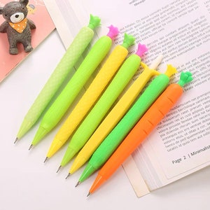 May include: Six colorful pencils with vegetable-shaped erasers. The pencils are green, yellow, and orange. The erasers are shaped like carrots, corn, and green beans.