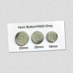 Puede incluir: Tres botones de cuerno grises de diferentes tamaños: 23 mm, 20 mm y 18 mm. Los botones tienen un patrón de mármol y cuatro agujeros.