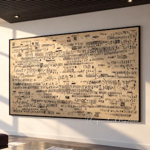 Puede incluir: Una gran pieza de arte mural rectangular con un fondo beige cubierto de densas marcas y símbolos negros abstractos que se asemejan a una escritura antigua. La obra está enmarcada con un borde negro fino y cuelga en una pared blanca.