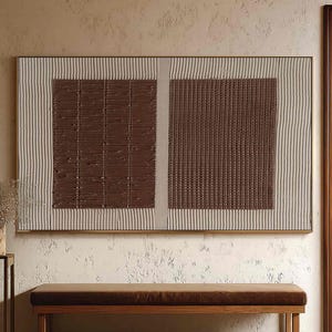 Puede incluir: Una obra de arte mural abstracta rectangular con una combinaci&oacute;n de colores marr&oacute;n y beige. La obra presenta dos cuadrados marrones texturizados, enmarcados por un borde beige con l&iacute;neas verticales. Debajo, un banco marr&oacute;n con estructura de madera y coj&iacute;n marr&oacute;n.