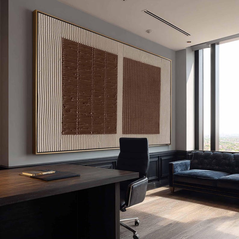 Puede incluir: Gran obra de arte abstracto con marco dorado. La obra presenta un dise&ntilde;o texturizado con cuadrados marrones y rayas verticales crema. Cuelga en una oficina moderna con un escritorio y un sof&aacute; azul.