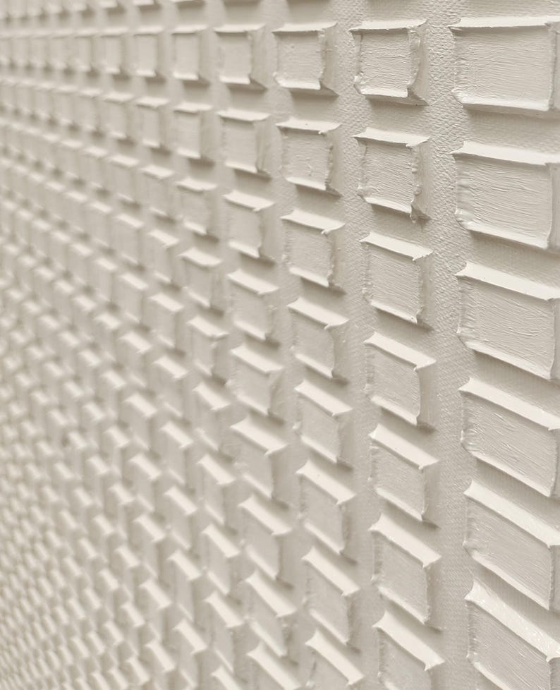 Puede incluir: Una pintura sobre lienzo de color blanco roto con textura que presenta un patr&oacute;n repetitivo de trazos de pintura impasto rectangulares y elevados dispuestos en cuadr&iacute;cula. La aplicaci&oacute;n gruesa de pintura crea una superficie tridimensional.