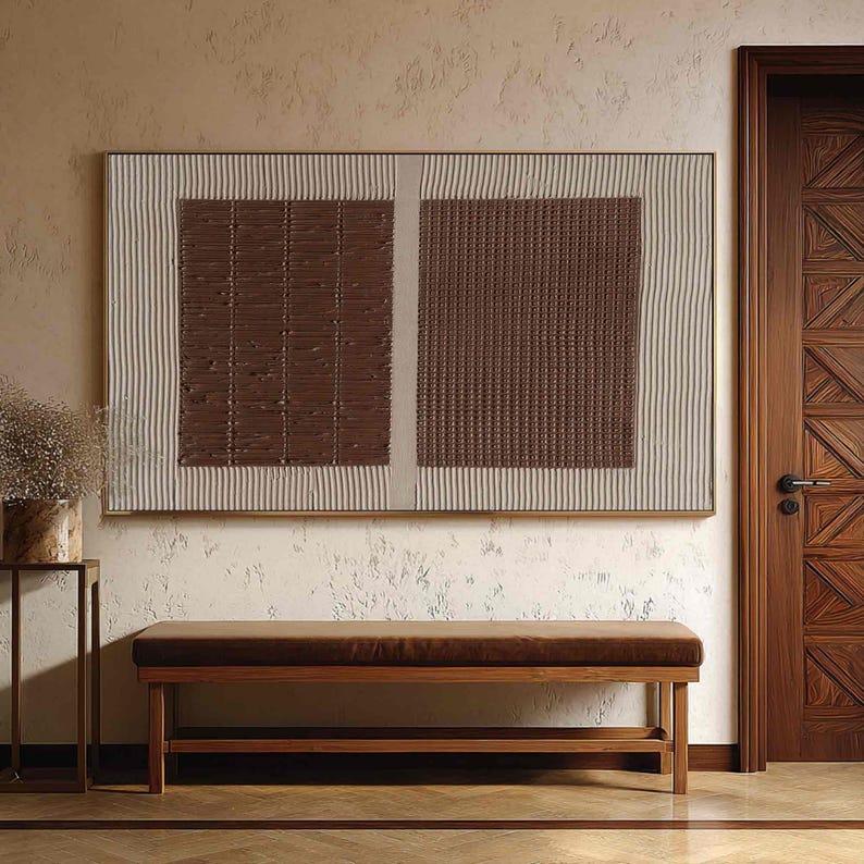 Puede incluir: Una obra de arte mural abstracta rectangular con una combinaci&oacute;n de colores marr&oacute;n y beige. La obra presenta dos cuadrados marrones texturizados, enmarcados por un borde beige con l&iacute;neas verticales. Debajo, un banco marr&oacute;n con estructura de madera y coj&iacute;n marr&oacute;n.