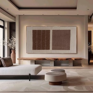 Puede incluir: Gran obra de arte mural abstracto con un dise&ntilde;o texturizado en tonos marr&oacute;n y crema. La obra de arte se exhibe sobre un banco de madera en un sal&oacute;n moderno. La habitaci&oacute;n presenta una paleta de colores neutros.