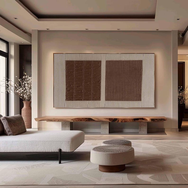 Puede incluir: Gran obra de arte mural abstracto con un dise&ntilde;o texturizado en tonos marr&oacute;n y crema. La obra de arte se exhibe sobre un banco de madera en un sal&oacute;n moderno. La habitaci&oacute;n presenta una paleta de colores neutros.