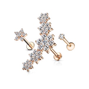 May include: Rose gold body jewelry with a cluster of clear cubic zirconia stones in a flower shape. The jewelry is designed for a cartilage piercing.