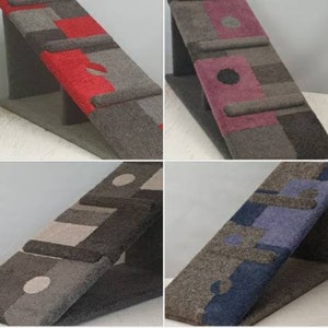 Puede incluir: Cuatro rascadores angulados para gatos con dise&ntilde;os geom&eacute;tricos. Cada rascador presenta una combinaci&oacute;n de colores diferente: rojo, morado, beige y azul. Los rascadores est&aacute;n hechos de un material texturizado similar a la alfombra y est&aacute;n soportados por una base triangular.