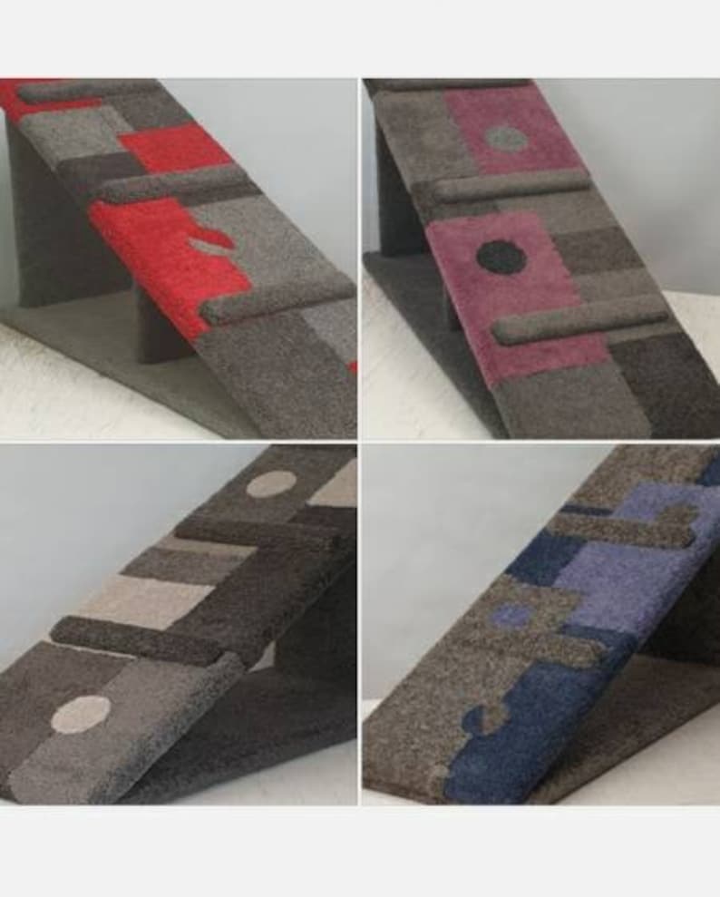 Puede incluir: Cuatro rascadores angulados para gatos con dise&ntilde;os geom&eacute;tricos. Cada rascador presenta una combinaci&oacute;n de colores diferente: rojo, morado, beige y azul. Los rascadores est&aacute;n hechos de un material texturizado similar a la alfombra y est&aacute;n soportados por una base triangular.