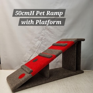 Puede incluir: Una rampa para mascotas con plataforma, con un dise&ntilde;o rojo y gris. La rampa mide aproximadamente 50 cm de alto y tiene una superficie texturizada. El texto "50cmH Pet Ramp with Platform" se muestra en la imagen.