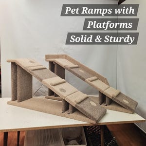 Puede incluir: Dos rampas beige para mascotas con plataformas. Las rampas est&aacute;n hechas de un material similar a la alfombra y tienen un dise&ntilde;o s&oacute;lido y resistente. El texto de la imagen dice "Pet Ramps with Platforms Solid & Sturdy."