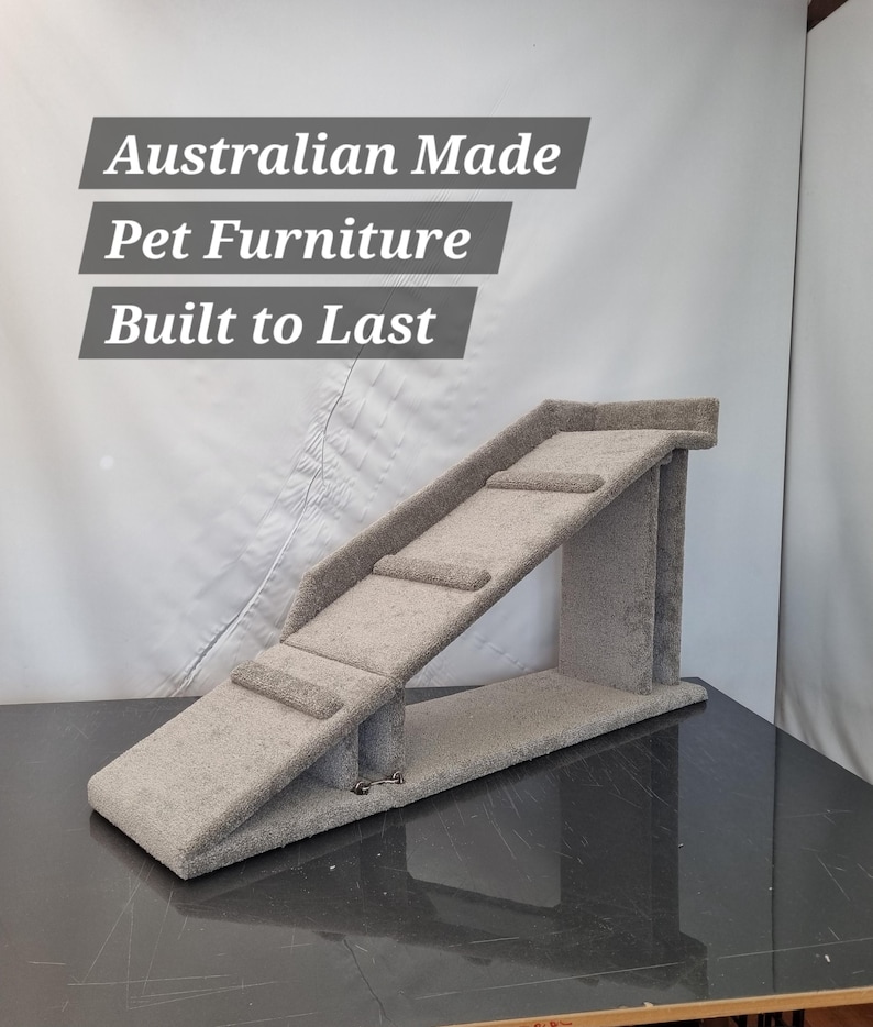 Puede incluir: Una rampa gris para mascotas con tres escalones y un dise&ntilde;o inclinado. La rampa est&aacute; hecha de un material suave similar a una alfombra y est&aacute; dise&ntilde;ada para mascotas. El texto en la imagen dice: Australian Made Pet Furniture Built to Last.
