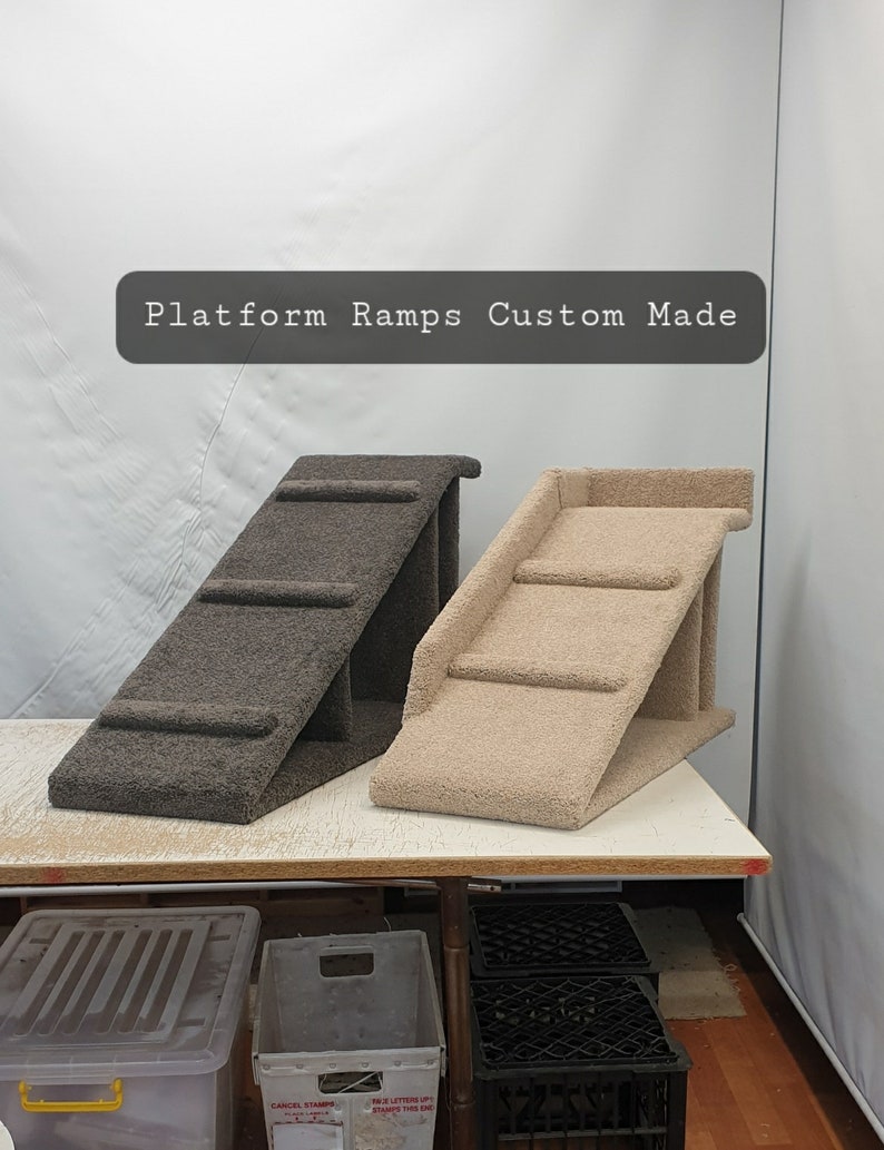 Puede incluir: Dos rampas de plataforma hechas a medida. Una es de color marr&oacute;n oscuro y la otra de color beige claro. Las rampas tienen una superficie texturizada similar a la alfombra y est&aacute;n dise&ntilde;adas con escalones. El texto "Platform Ramps Custom Made" se muestra encima de las rampas.