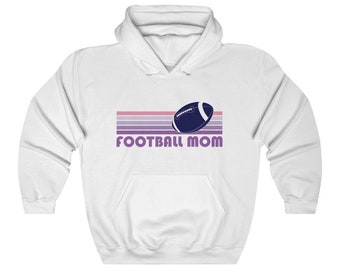 May include: White hooded sweatshirt with a retro-style design featuring a football and the text "FOOTBALL MOM" in purple.