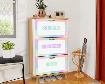 May include: A three-drawer shoe storage cabinet with labels for sandals, sneakers, and boots. The cabinet has a light wood frame and pastel-colored drawer fronts. A decorative umbrella stand and a small bench are nearby.