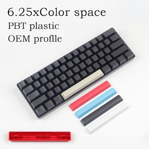 May include: A black keyboard with keycaps and replacement keycaps in red, light blue, black, and white. The keyboard has a light gray space bar. Text on the image reads: 6.25xColor space, PBT plastic, OEM profile.
