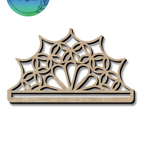 May include: A wooden cutout of a decorative design with a geometric pattern. The design is in the shape of a crown with a flat base.