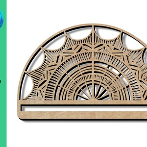 Könnte beinhalten: Ein halber Kreis aus Holz mit einem ausgeschnittenen geometrischen Muster. Das Muster erinnert an ein Mandala oder einen Sonnenstrahl. Der Halbkreis ist etwa 25 cm breit.