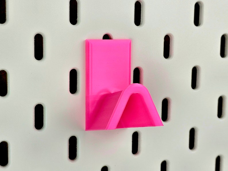 Pink glasses rack on white pegboard