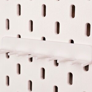 May include: White plastic pegboard hook with seven prongs. The hook is designed to hang on a pegboard.