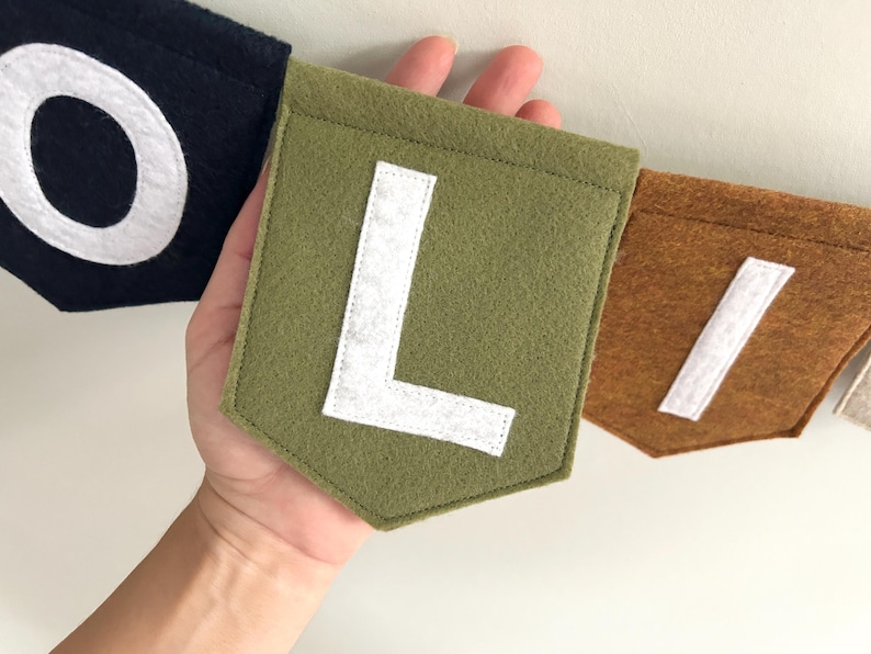 Close-up of hand-cut felt letters on customizable flag banner for baby name decoration