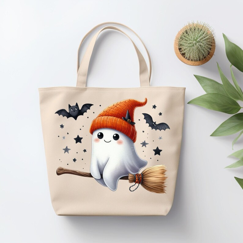 May include: A beige tote bag with a cute cartoon ghost wearing an orange and black witch hat and riding a broomstick. The ghost is surrounded by black bats and white stars.