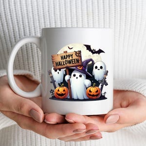 K&ouml;nnte beinhalten: Wei&szlig;e Keramiktasse mit einem Halloween-Motiv. Das Design zeigt drei Cartoon-Geister, zwei K&uuml;rbisse, eine Fledermaus und ein Schild mit der Aufschrift "Happy Halloween".
