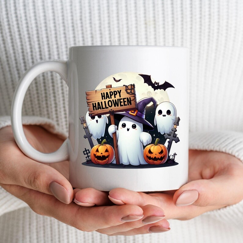 K&ouml;nnte beinhalten: Wei&szlig;e Keramiktasse mit einem Halloween-Motiv. Das Design zeigt drei Cartoon-Geister, zwei K&uuml;rbisse, eine Fledermaus und ein Schild mit der Aufschrift "Happy Halloween".