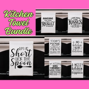 May include: A set of 8 white kitchen towels with black text. The towels feature funny kitchen-themed sayings such as "Life is Short, Lick the Spoon", "Today's Menu, Take It or Leave It", and "A Messy Kitchen is a Sign of Happiness".