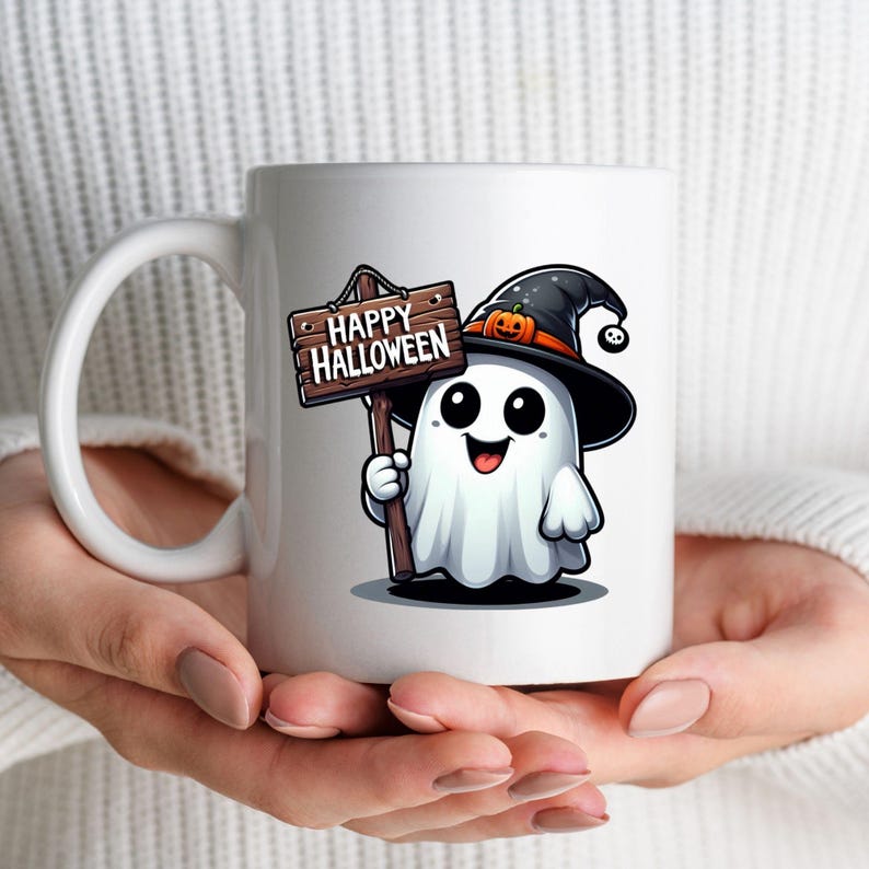 K&ouml;nnte beinhalten: Wei&szlig;e Keramiktasse mit einem Cartoon-Geist, der einen Hexenhut tr&auml;gt und ein Schild mit der Aufschrift "Happy Halloween" h&auml;lt.