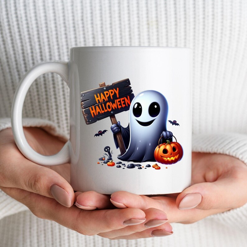 K&ouml;nnte beinhalten: Wei&szlig;e Keramik-Kaffeetasse mit einem Cartoon-Geist, der ein Schild mit der Aufschrift "Happy Halloween" und einen K&uuml;rbis h&auml;lt. Der Geist l&auml;chelt und hat gro&szlig;e Augen.