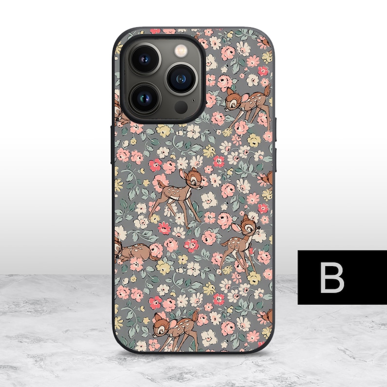 K&ouml;nnte beinhalten: Eine graue Handyh&uuml;lle mit einem Blumenmuster, das ein sich wiederholendes Design von Bambi und Klopfer aus Disneys Bambi zeigt. Die H&uuml;lle hat eine schwarze Kamerabuckel mit drei Linsen.