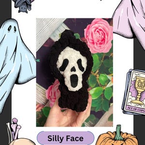 May include: A black and white crocheted Ghostface mask from the Scream movie franchise. The mask is held in a hand against a background of pink roses and green leaves. The text "Silly Face" is written in purple on a light purple background.