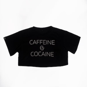 May include: Black cropped t-shirt with white text that reads "CAFFEINE & COCAINE".