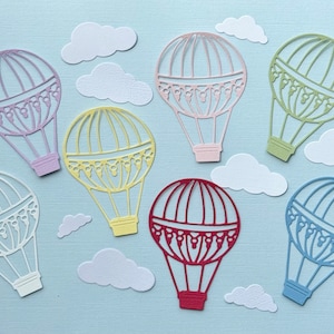 May include: Seven paper cut-outs of hot air balloons in various colours, including purple, yellow, green, red, and blue, with white clouds in the background.