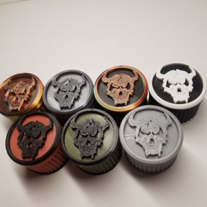 May include: Seven round bottle stoppers with a skull design. The stoppers are in various colors including black, white, gray, red, orange, and green.