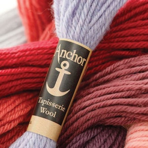 May include: A close-up of a skein of lavender wool yarn with a label that reads "Anchor Tapisserie Wool". The label features a black anchor symbol.
