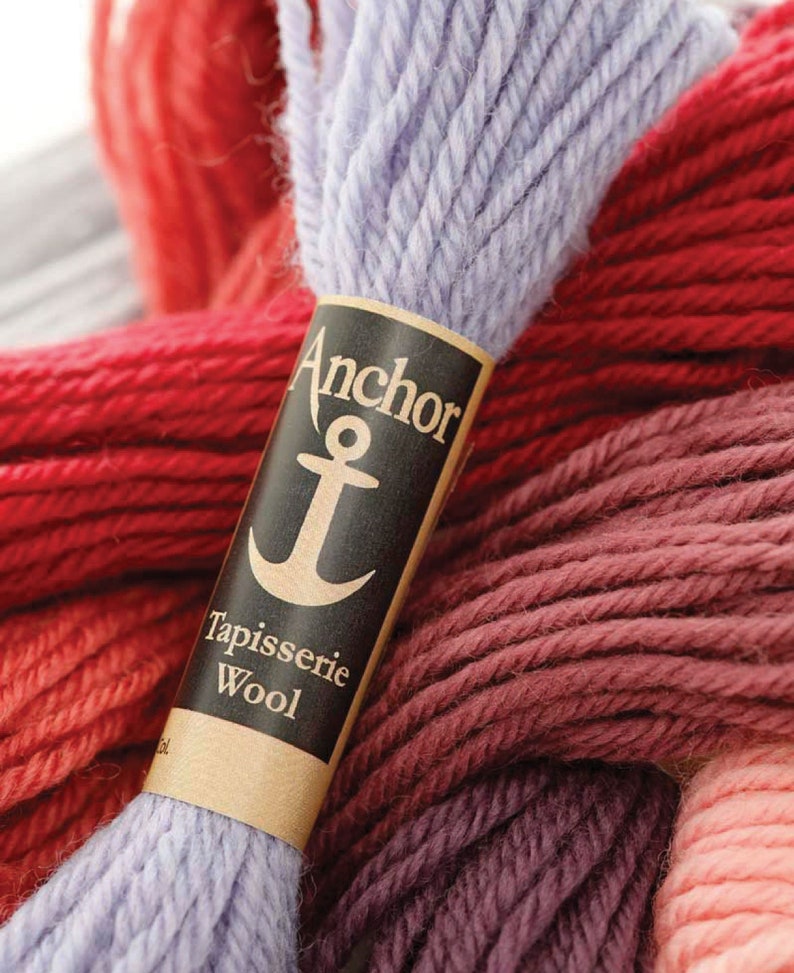 May include: A close-up of a skein of lavender wool yarn with a label that reads "Anchor Tapisserie Wool". The label features a black anchor symbol.