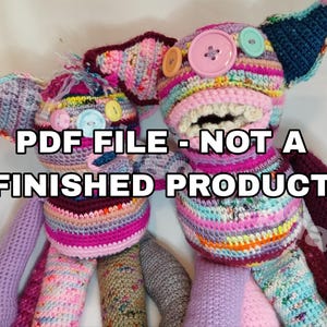 Puede incluir: Dos muñecos de ganchillo hechos a mano, con colores vibrantes, con ojos de botón y orejas grandes. Los muñecos están hechos con varios hilos, incluyendo rosa, morado, azul y amarillo. El texto en la imagen dice "PDF FILE - NOT A FINISHED PRODUCT."