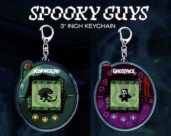 May include: Two keychains, each 3 inches in size, featuring a retro handheld game design. One has a green and black Xenomorph graphic, the other a purple and red Ghostface graphic. The text "Spooky Guys" is at the top.
