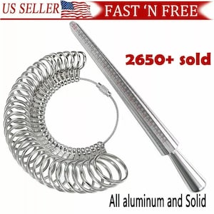 May include: A silver ring sizer with a chain and a silver measuring stick. The ring sizer has 26 sizes of rings. The measuring stick has markings in inches and millimeters. The text "2650+ sold" is visible in the image. The text "All aluminum and Solid" is visible in the image.