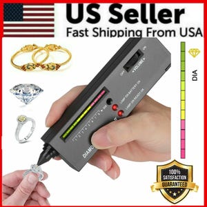 May include: A black diamond tester with a digital display and a small light. The tester is being used to test a ring with a clear stone. The tester has a volume control and a switch to turn the light on and off. The tester also has a display that shows the results of the test. The tester is labeled "DIAMOND" and has a scale from 1 to 8. The tester is also labeled "LAMP ON BATTERY OK" and "LAMP ON READY OK".