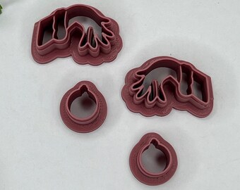 May include: Four red plastic cookie cutters, two shaped like hands, one shaped like a round ornament, and one shaped like a smaller round ornament.
