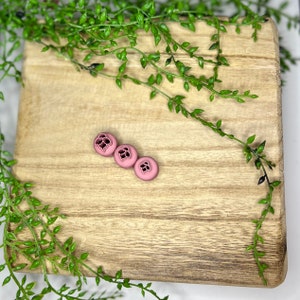 Peut inclure: Trois chouchous en silicone rose avec un motif floral.